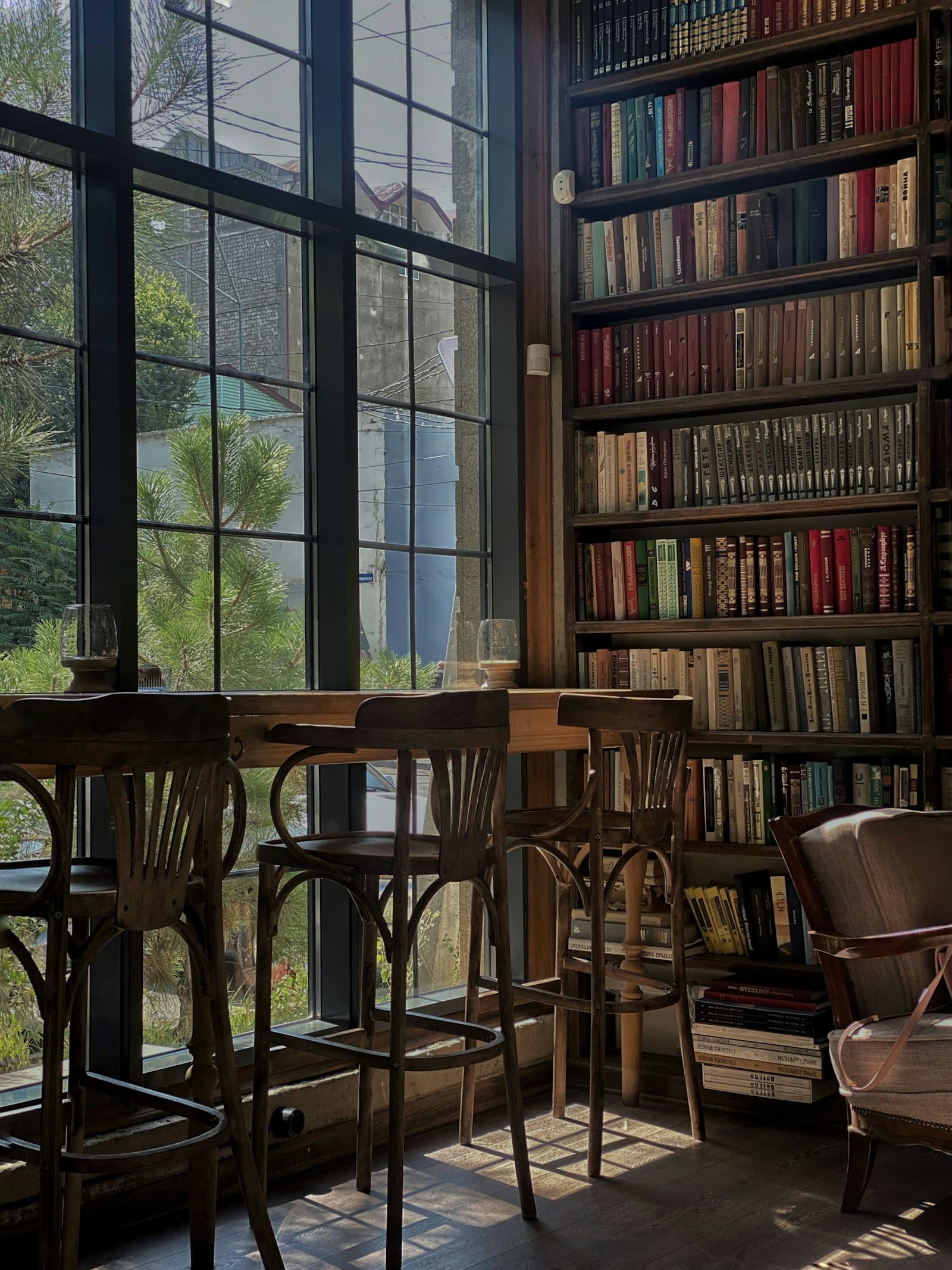 A classroom reading corner with tall windows and shelves of books